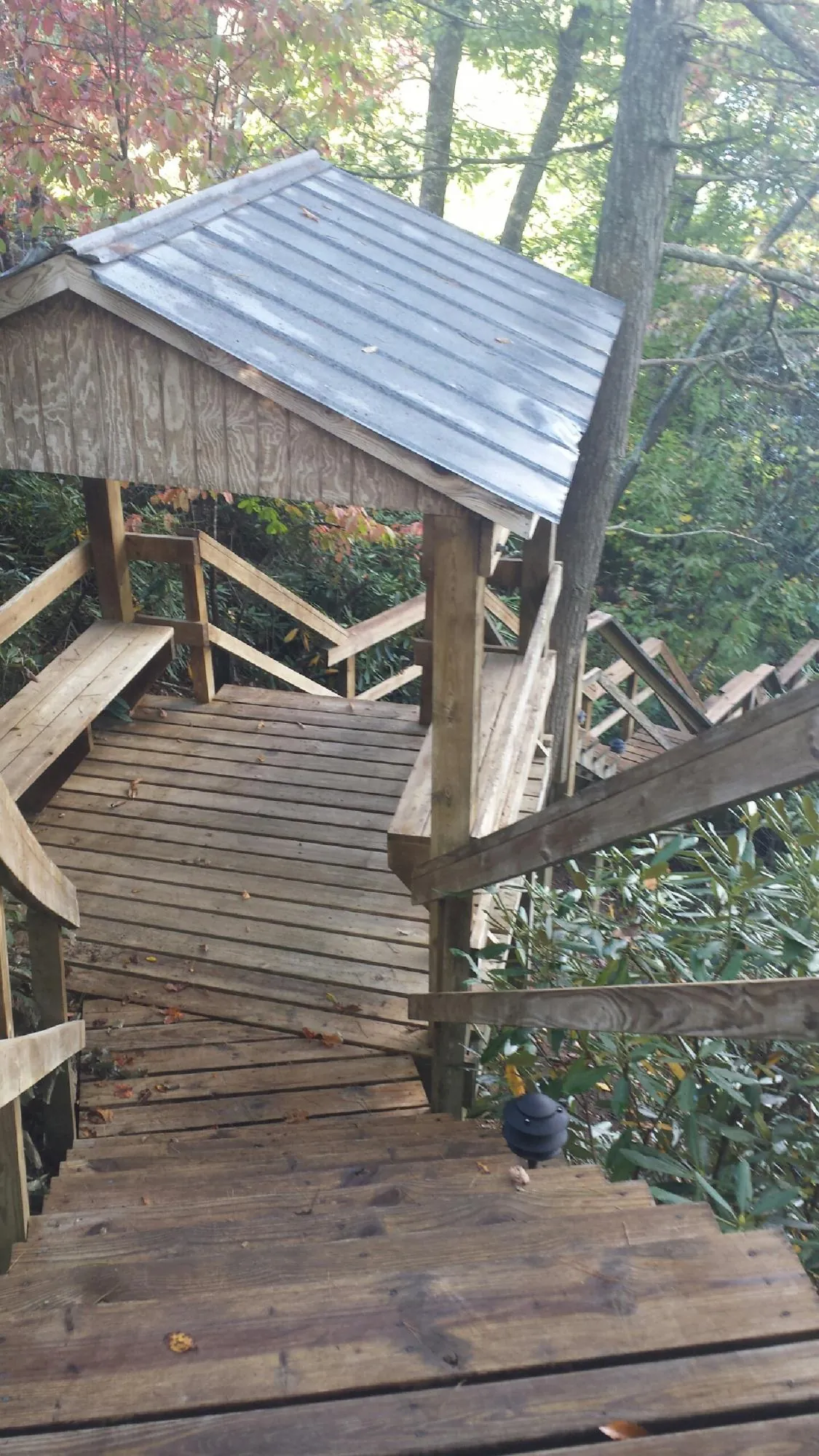 Metal roofed shelter over wooden steps on a wooded walkway — Skylight Repair & Installation work by our crew in Oakhurst