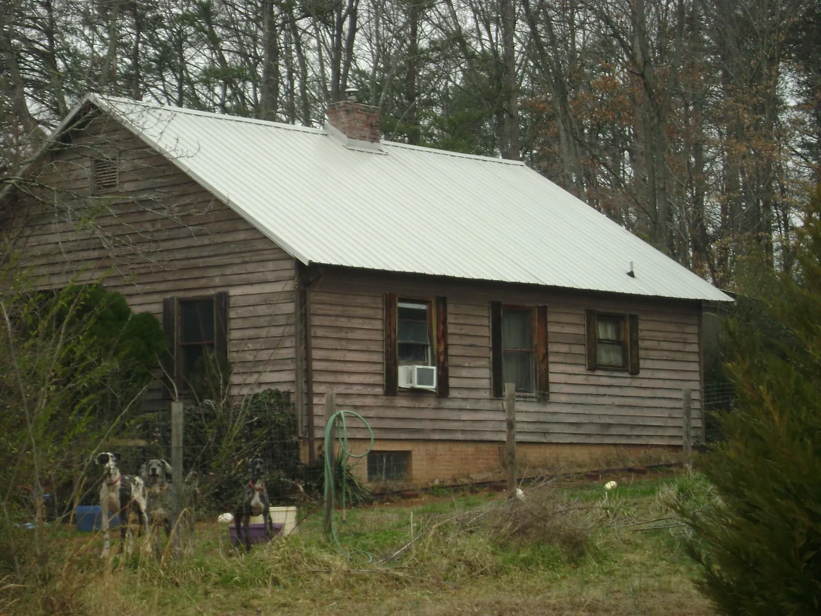 White metal roof on an old wood sided farmhouse, from a Metal Roof Installation job in Oakhurst